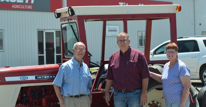 Dick and Carolee pose in front of their tractor, "Aggie," with Chad Fisher, Titan Machinery Case-IH 