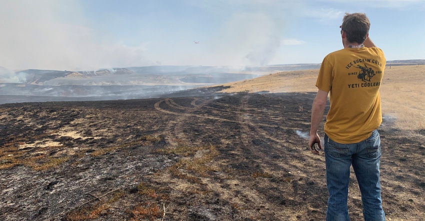 Ryan Monsen looks out over a grassland fire near his family farm in McKenzie County, North Dakota.