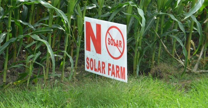 "no solar panels" sign in field