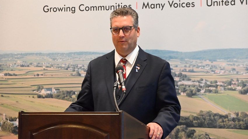 Chris Hoffman, president of Pennsylvania Farm Bureau speaking into a microphone at a podium