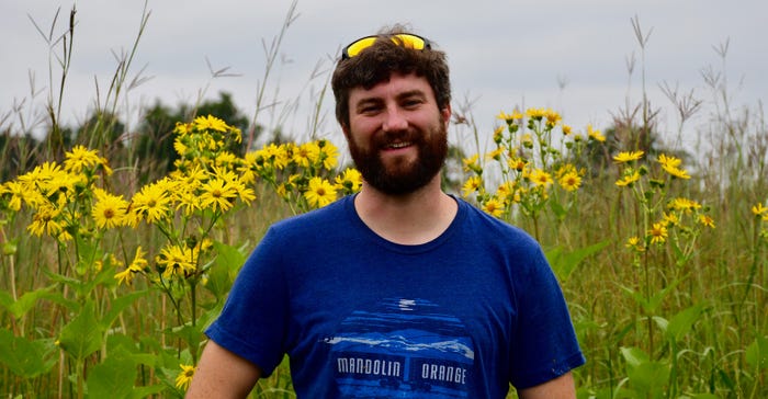 Sean Griffin stands in front of one of the research plots where he looking for native bees