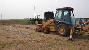 equipment installing drainage tile in farm field