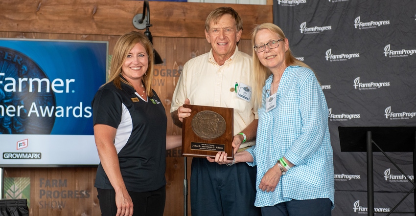 Holly Spangler presents John and Susan Adams with their Master Farmer award