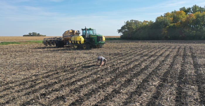 a farmer checks his fertilizer placement after he has strip tilled his sunflower stubble