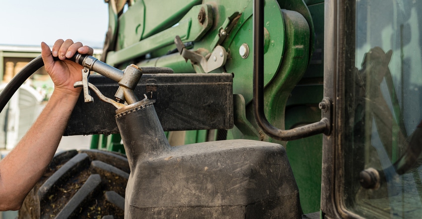 farmer putting fuel in his tractor