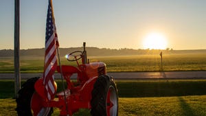 A closeup of a patriotic tractor with the US flag at sunrise