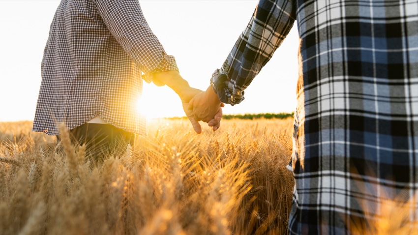 two people in field holding hands