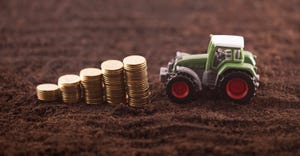 Miniature tractor with coins on soil