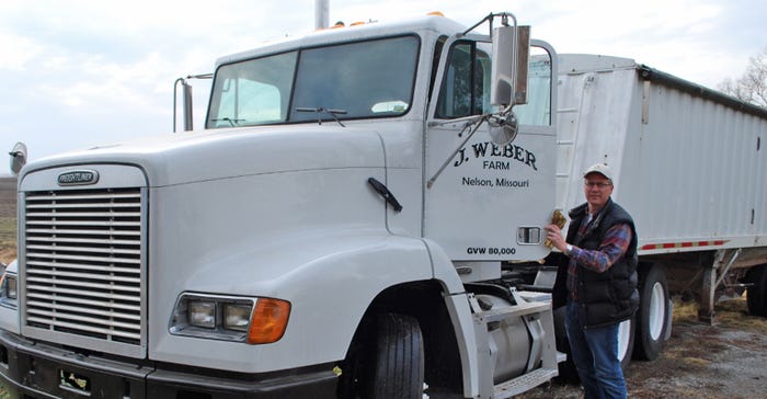 Alan Weber standing alongside a white J. Weber Farm truck