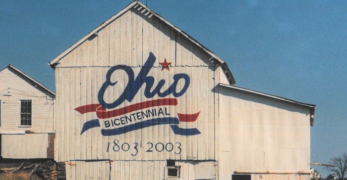 A white barn painted with blue and red paint and reads "Ohio Bicentennial 1803-2003"