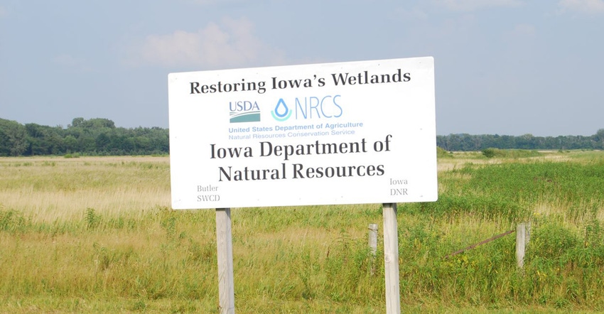 Restoring Iowa's wetlands sign in field