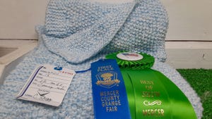 A  baby blanket wears the Best of Show ribbon for Carol Ann Gregg at the Mercer County Grange Fair