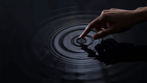 Female finger touching water, creating ripples