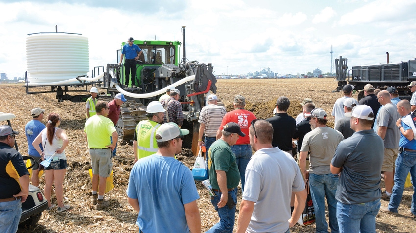 group of people watching a tiling demo in a field