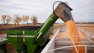Grain cart loading semi trailer with corn in fall during harvest