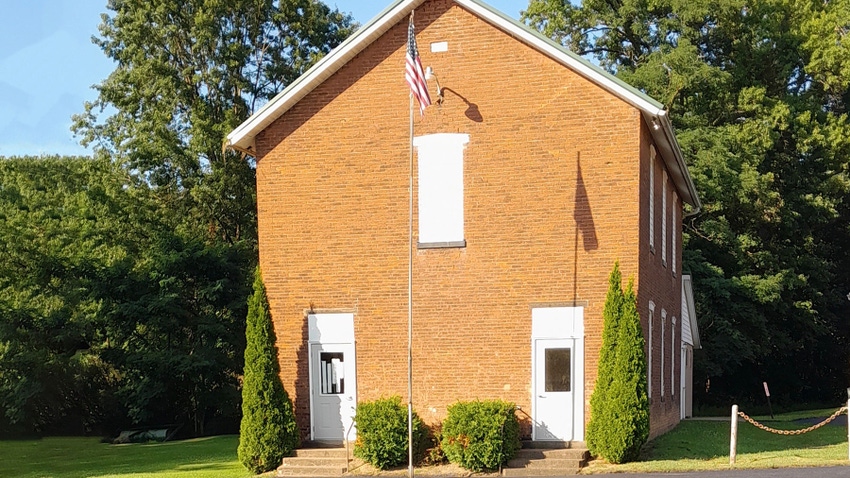 A tall brick building and a flagpole flying an American flag