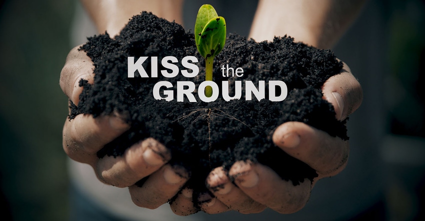 Kiss the Ground image of hands holding dirt with soybean sprout.