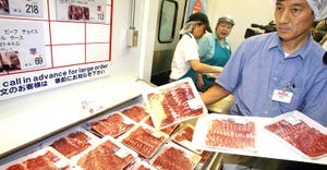 man stocking packaged meat counter
