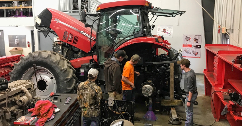 A group of students working on a Case IH tractor
