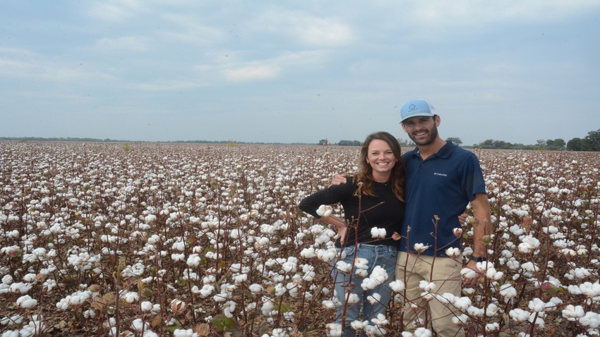 A man and woman in a field with white cotton bolls