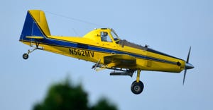small yellow plane in sky