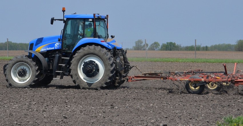 tractor performing tillage in field