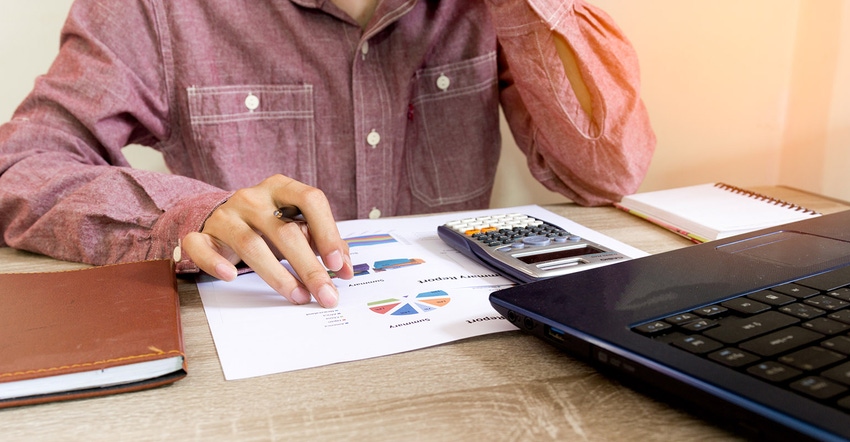 Man with calculator working on finances