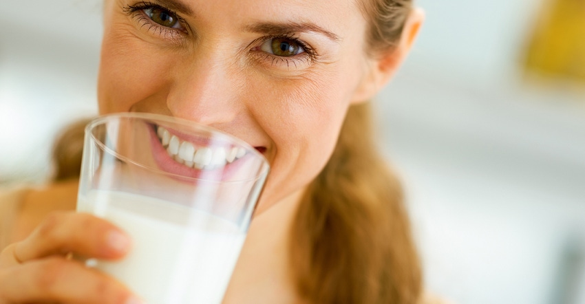 smiling woman drinking glass of milk