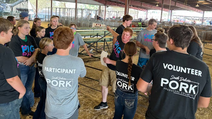  Adam Krause, a swine producer from Clear Lake, S.D., gives directions to youth volunteers