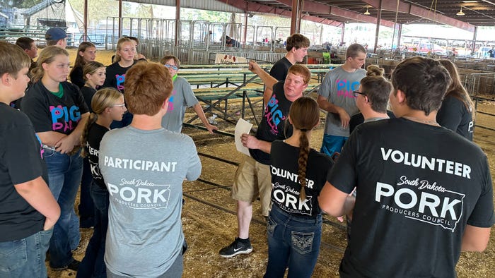 Adam Krause, a swine producer from Clear Lake, S.D., gives directions to youth volunteers Adam Krause, a swine producer from Clear Lake, S.D., gives directions to youth volunteers