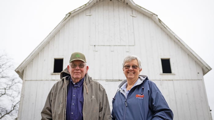 Curt and Mary Strode stand in front of white barn