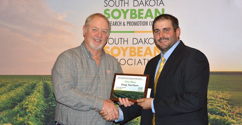 Doug Van Duyn (left) receives overall first place plaque in S.D. Soybean Yield Contest from Jon Schaeffer