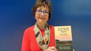 Susan Hayhurst smiles as she holds a copy of her book