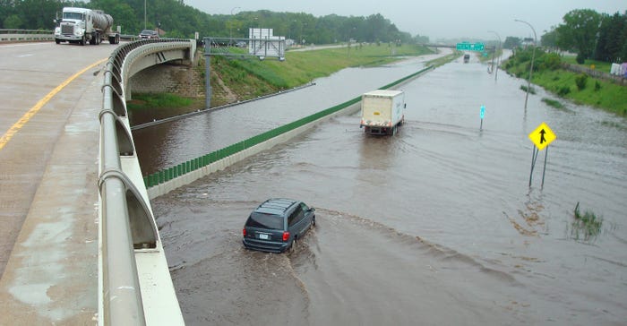 Vehicles driving through a stretch of Interstate 90 flooded by the nearby Dobbins Creek in June 2008 