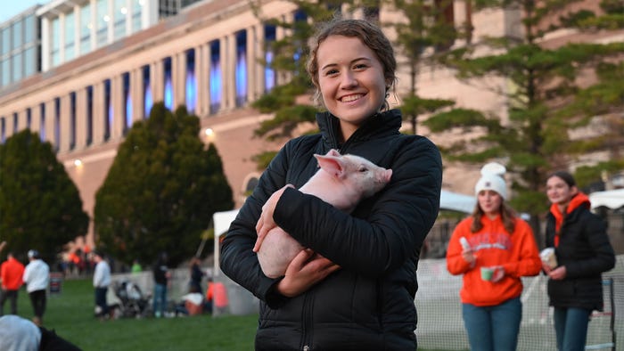 Olivia Shike holding a small pig as the Illini prepared for kickoff in Memorial Stadium