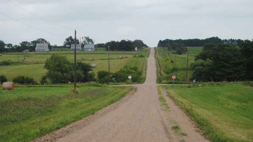 farm road with barns and rolling hills