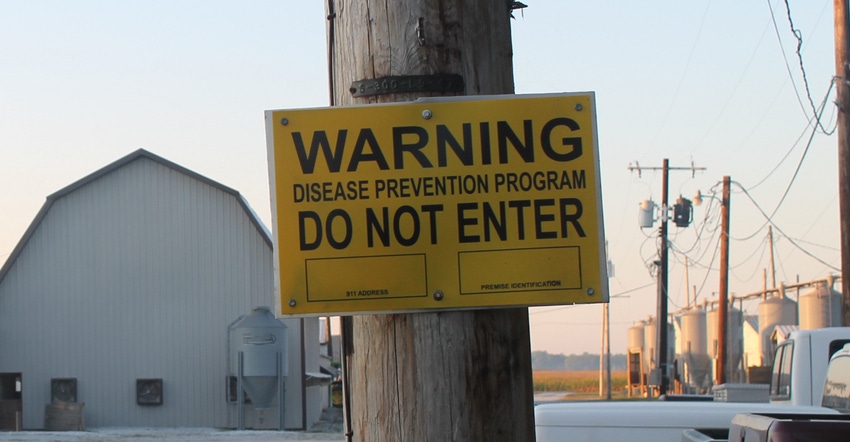 biosecurity warning sign posted on pole outside barn