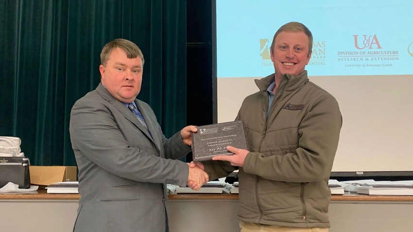 Two men, with one presenting award plaque to the other.