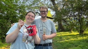 Allison Lund and Ryan Lynch pose with a paint bucket and brush
