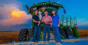 three generations of farmers standing on farm equipment