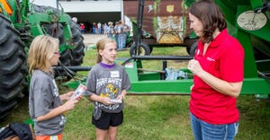 A county Extension worker talks to two young students