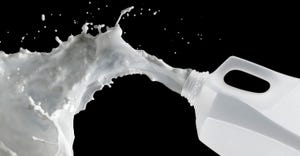 Milk splashes out of a gallon jug