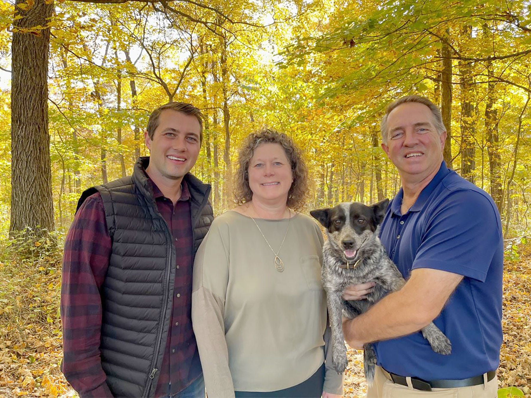Picture from left: Joe, Diana, the family dog and Dave Fischer standing in a woods in the fall