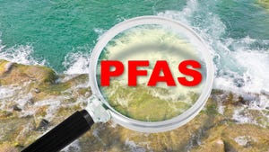 Concept photo of magnifying glass with PFAS over it in red letters