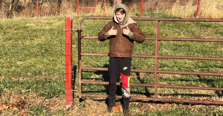 Graham Curtis giving a thumbs-up while standing in front of a gate
