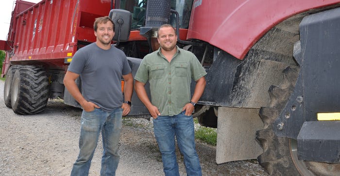 Kelsey and Michael Gettelfinger in front of three-wheel fertilizer applicator 