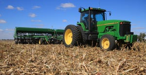 John Deere tractor and planter in field with cornstalk residue