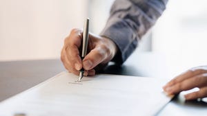  A close up of a hand signing a contract