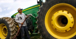Farmer putting fuel in John Deere tractor