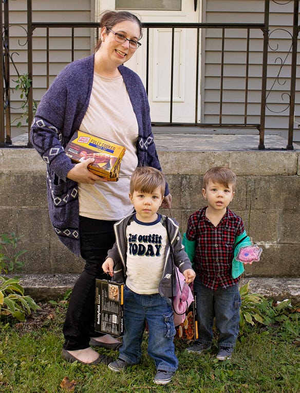Lacie Ball, with twin two-year-old sons Rowan and Hunter, holds a box of bacon